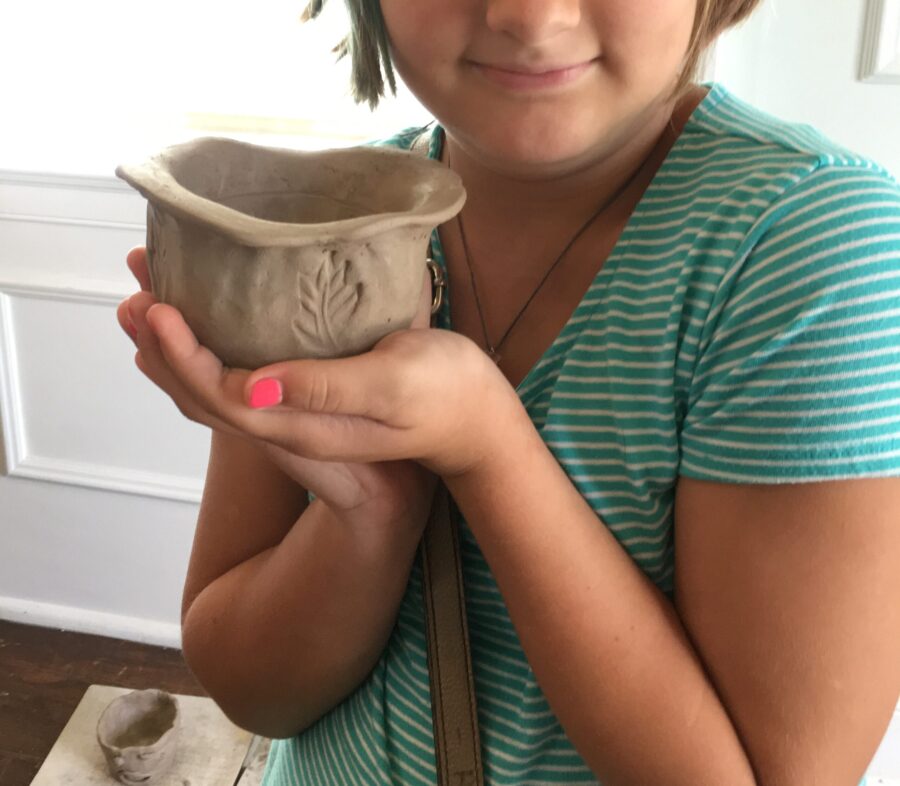 child holding pottery