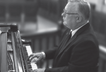black and white image of andy reid playing the piano